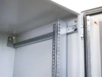 RESISTER PRO IP66 mit geöffneter Tür, Blick auf Tiefenverstellung der 19-Zoll-Schiene und Türscharnier mit Dichtungsrahmen